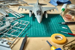 Top view on plastic model scale with accessories on  green pad on bright wooden table